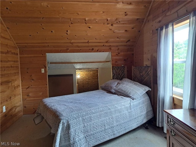 carpeted bedroom featuring vaulted ceiling and wooden walls