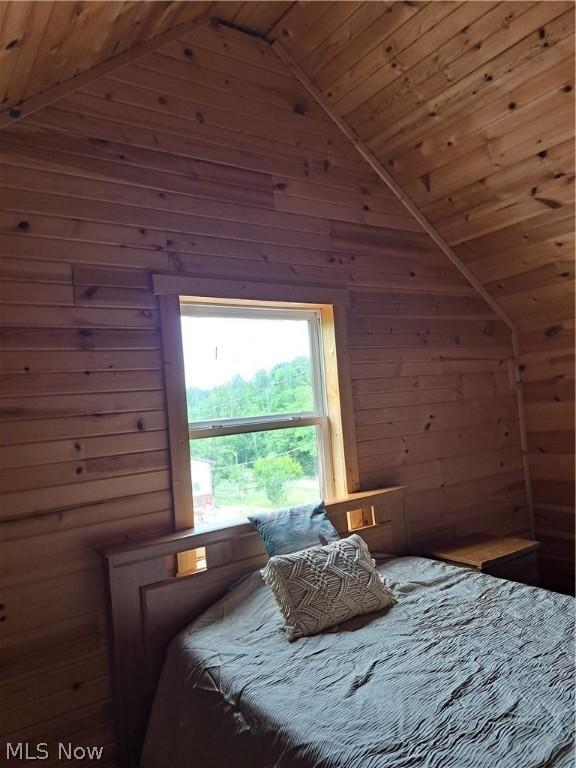 bedroom featuring wood ceiling, lofted ceiling, and wood walls