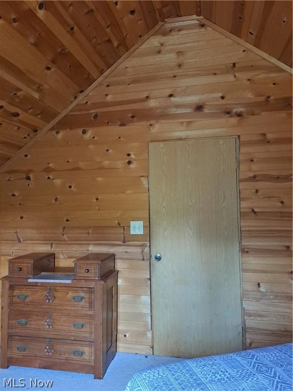 unfurnished bedroom with wooden ceiling and wooden walls