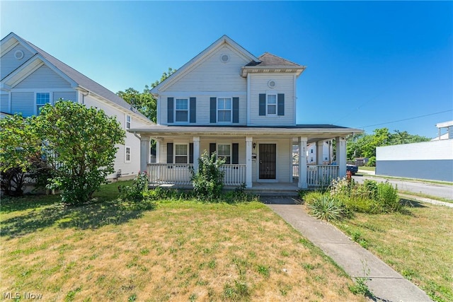 view of front facade with a front yard and covered porch