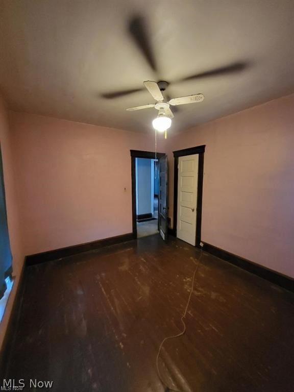 spare room featuring dark hardwood / wood-style floors and ceiling fan