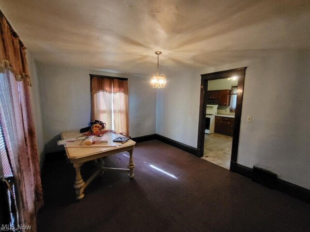 unfurnished dining area featuring a chandelier