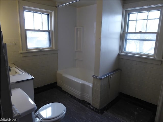 full bathroom featuring vanity, shower / washtub combination, toilet, and tile walls