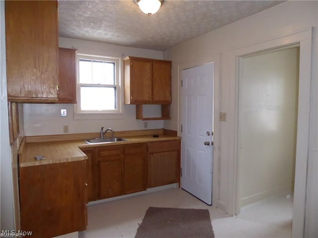 kitchen featuring a textured ceiling and sink