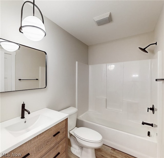 full bathroom with shower / washtub combination, hardwood / wood-style flooring, toilet, and vanity