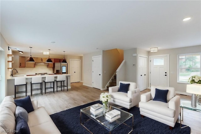 living room featuring sink and light hardwood / wood-style flooring