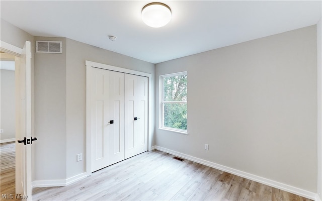 unfurnished bedroom featuring light hardwood / wood-style floors and a closet