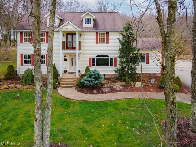 view of front of property featuring a balcony and a front lawn