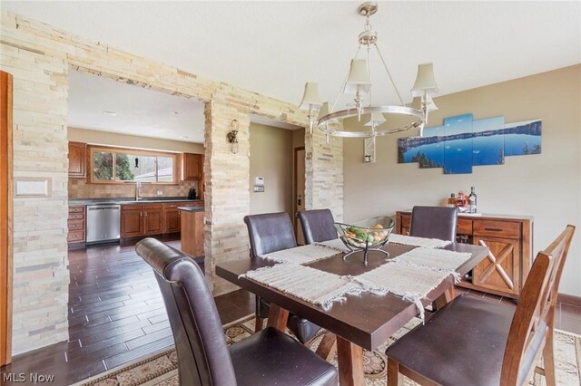 dining room featuring dark wood-type flooring, an inviting chandelier, and sink