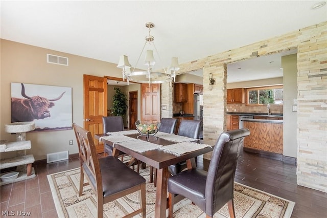 dining area with dark wood-type flooring and a chandelier