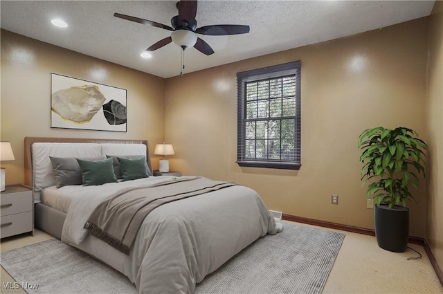 carpeted bedroom with ceiling fan and a textured ceiling