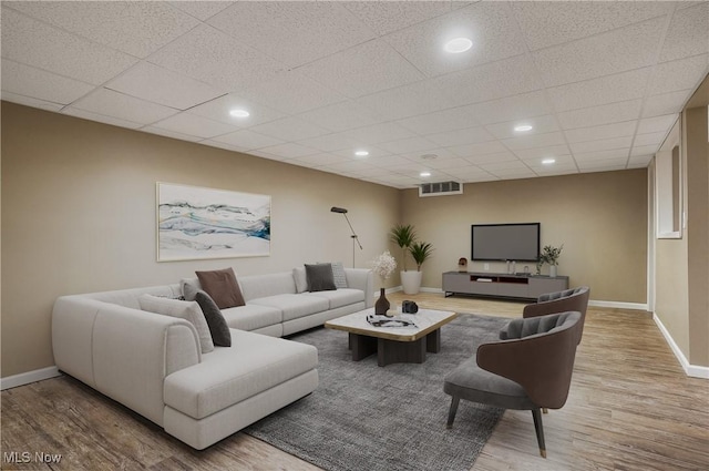 living room featuring a paneled ceiling and hardwood / wood-style floors