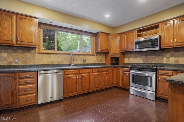 kitchen with stainless steel appliances, tasteful backsplash, sink, and dark hardwood / wood-style flooring