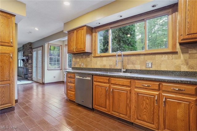 kitchen with a wealth of natural light, dark wood-type flooring, sink, and dishwasher