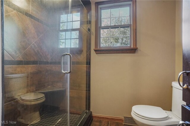 bathroom featuring walk in shower, hardwood / wood-style floors, and toilet