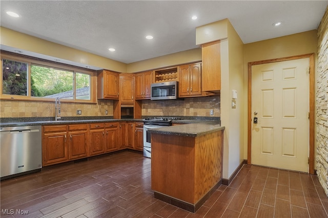 kitchen with sink, decorative backsplash, dark hardwood / wood-style floors, appliances with stainless steel finishes, and a textured ceiling