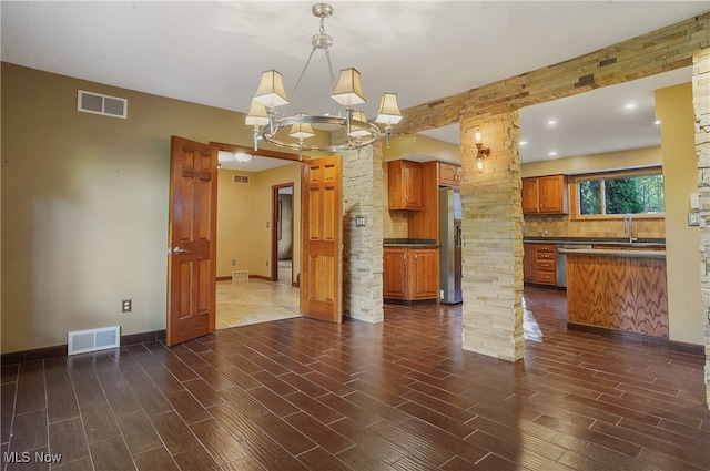 interior space with decorative columns, a notable chandelier, and sink