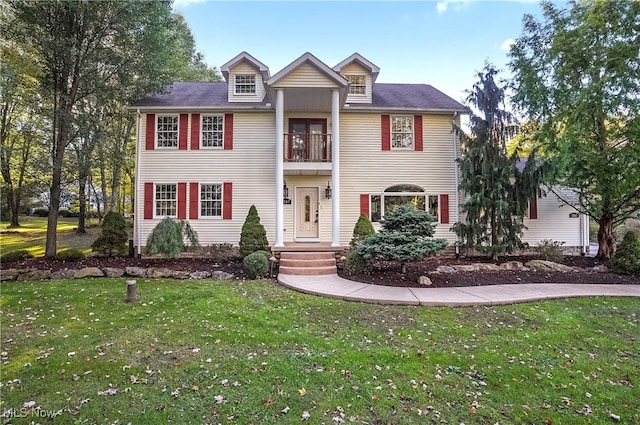 view of front of house featuring a front yard and a balcony