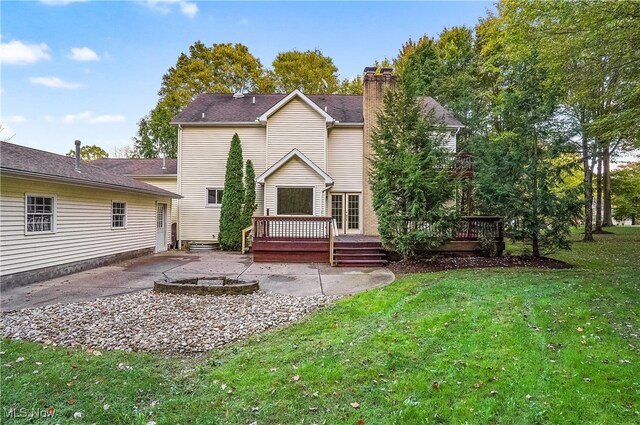 back of property with a yard, a deck, and a patio area