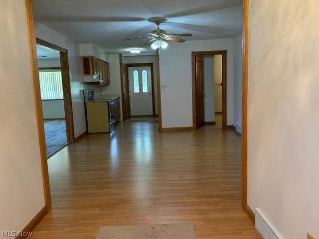 interior space with light hardwood / wood-style flooring, range with electric cooktop, and ceiling fan