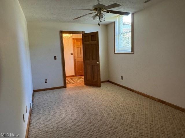 unfurnished room with light carpet, ceiling fan, and a textured ceiling