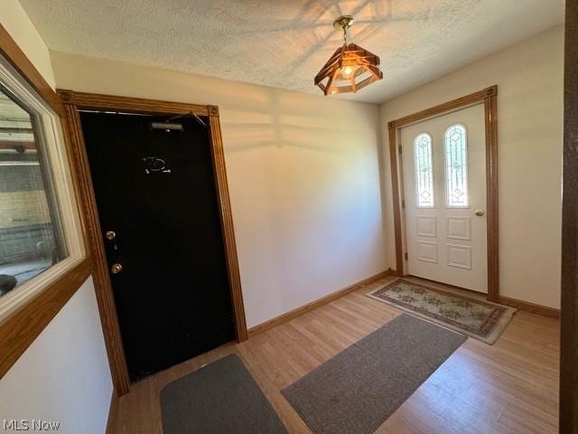 foyer featuring a textured ceiling and light wood-type flooring