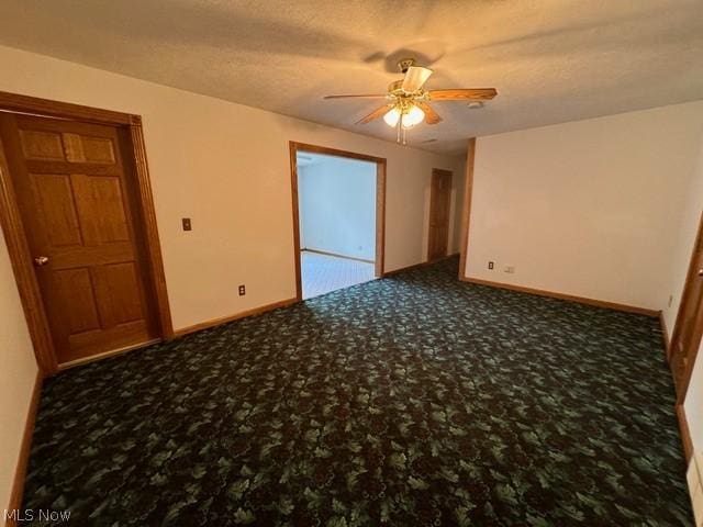 carpeted empty room featuring ceiling fan and a textured ceiling