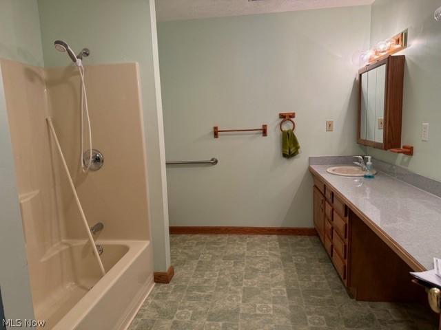 bathroom featuring vanity and  shower combination