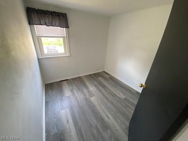 empty room with dark hardwood / wood-style flooring