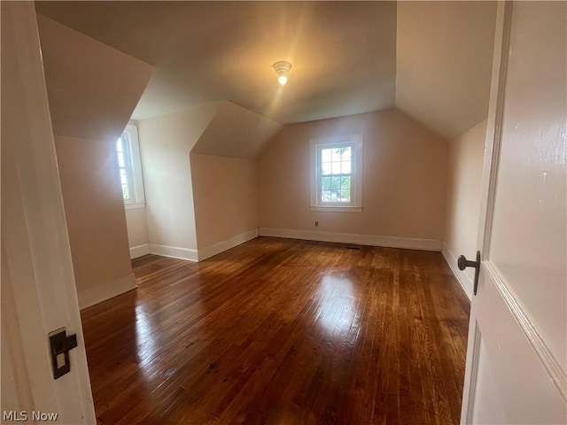 additional living space with lofted ceiling and dark hardwood / wood-style floors