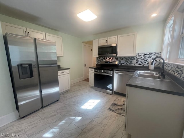 kitchen featuring white cabinetry, appliances with stainless steel finishes, sink, and tasteful backsplash