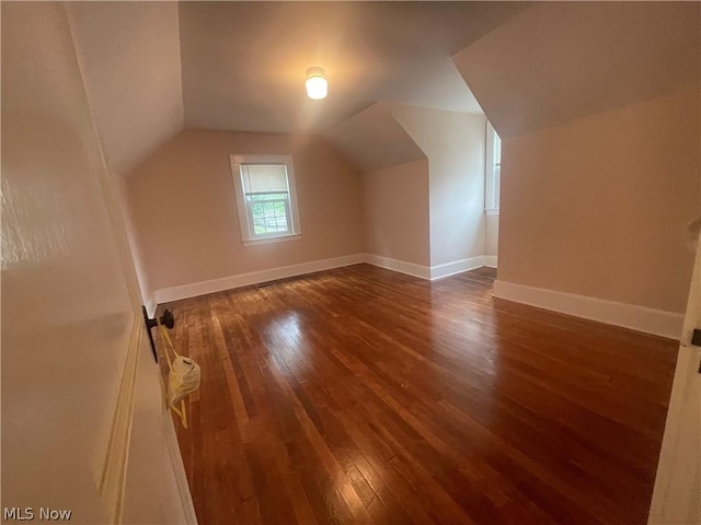 bonus room featuring lofted ceiling and dark hardwood / wood-style flooring