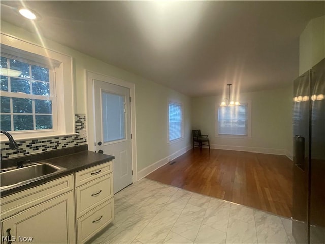 kitchen with tasteful backsplash, sink, and hanging light fixtures