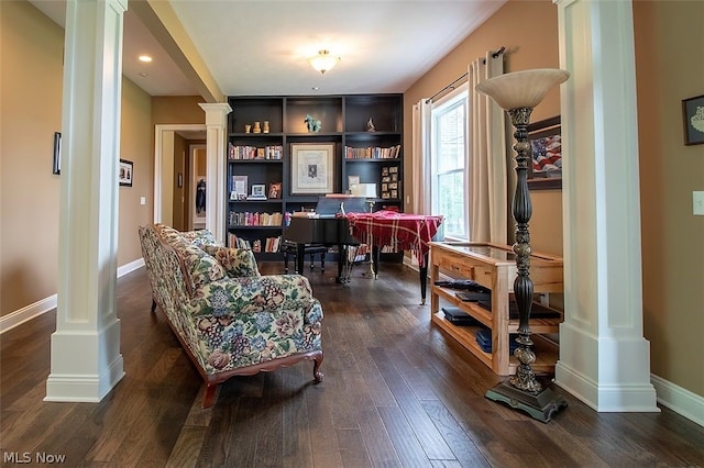 living area featuring dark wood-type flooring and decorative columns