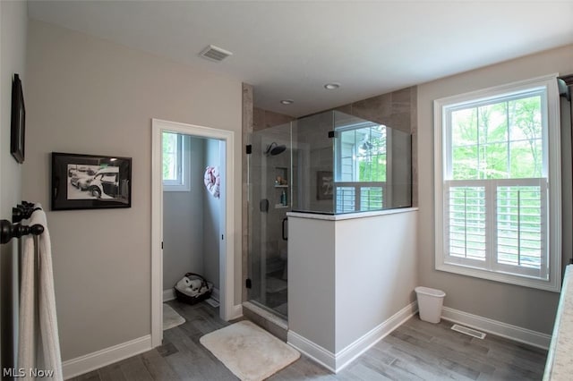 bathroom with hardwood / wood-style floors and a shower with shower door