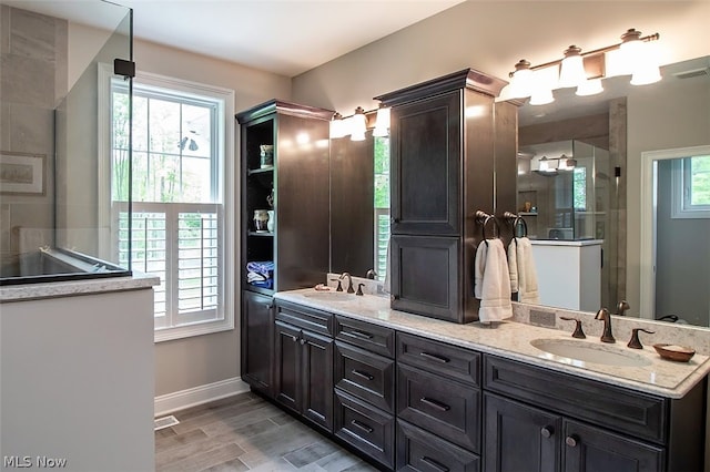 bathroom with a wealth of natural light, wood-type flooring, and vanity