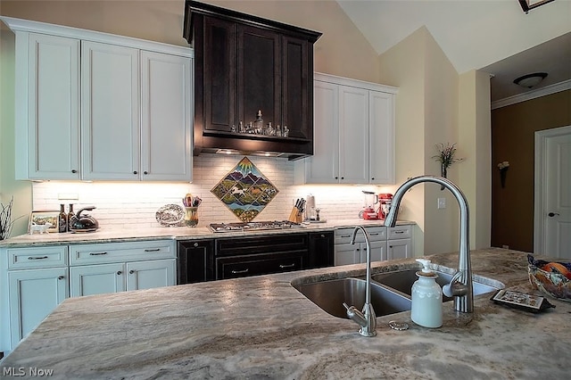 kitchen featuring white cabinetry, sink, decorative backsplash, stainless steel gas stovetop, and vaulted ceiling