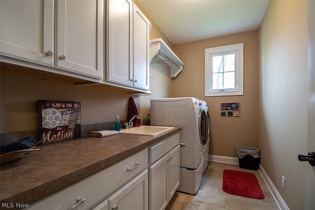 laundry room with washing machine and clothes dryer, cabinets, and sink