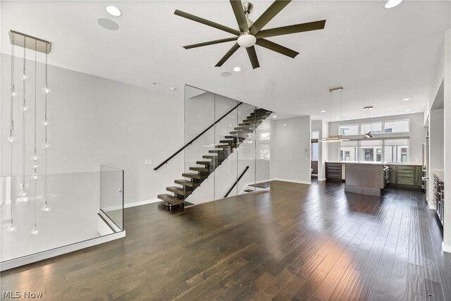 unfurnished living room featuring ceiling fan and dark hardwood / wood-style flooring