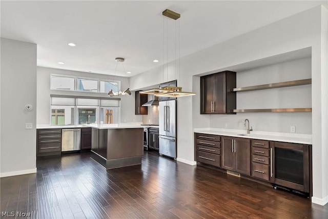 kitchen featuring appliances with stainless steel finishes, pendant lighting, beverage cooler, dark hardwood / wood-style flooring, and dark brown cabinetry