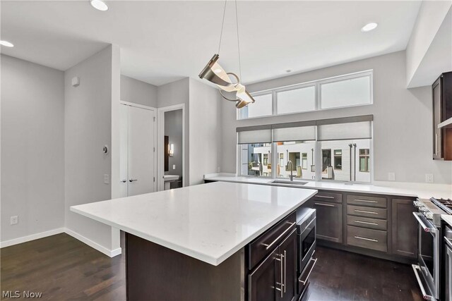 kitchen featuring appliances with stainless steel finishes, sink, dark hardwood / wood-style floors, and a kitchen island