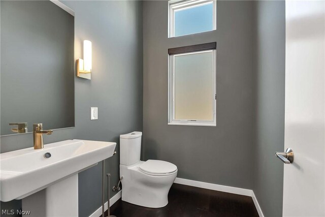 bathroom with hardwood / wood-style floors, sink, and toilet