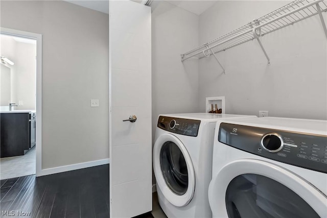 laundry room with separate washer and dryer and dark wood-type flooring