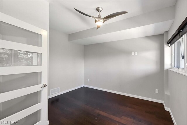 spare room with ceiling fan and dark wood-type flooring