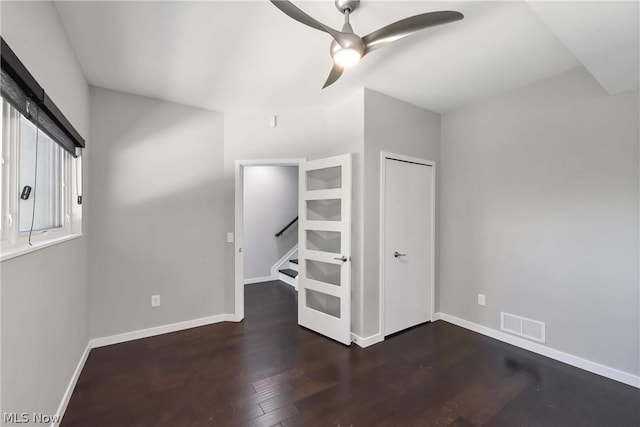 empty room with dark hardwood / wood-style floors and ceiling fan