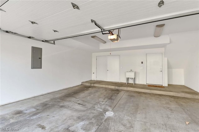 garage with sink, a garage door opener, and electric panel