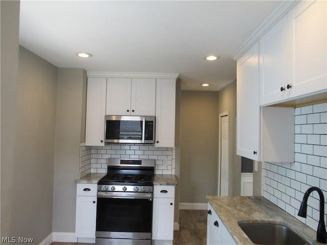 kitchen featuring white cabinets, sink, and appliances with stainless steel finishes