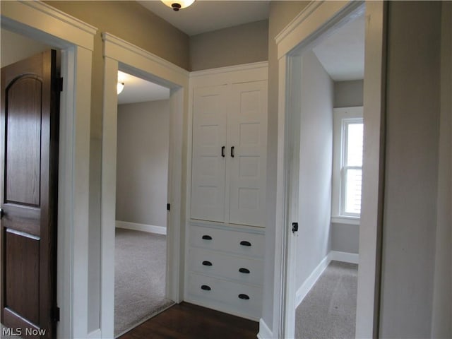 hall with dark colored carpet