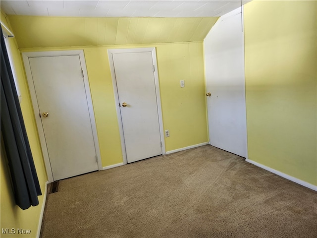 unfurnished bedroom with light carpet and lofted ceiling