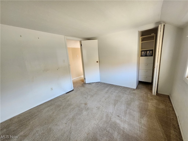 carpeted spare room featuring vaulted ceiling